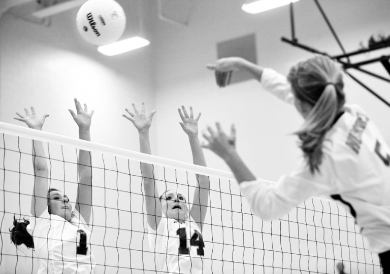 Black and white high school volleyball action.