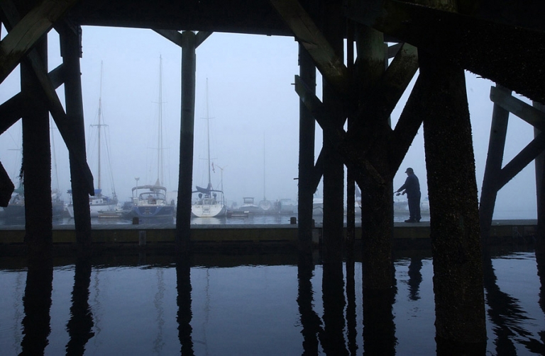 New England Fisherman fishing by the Beverly, MA harbor on a cold day by travel photographer Kira Vos (Horvath).