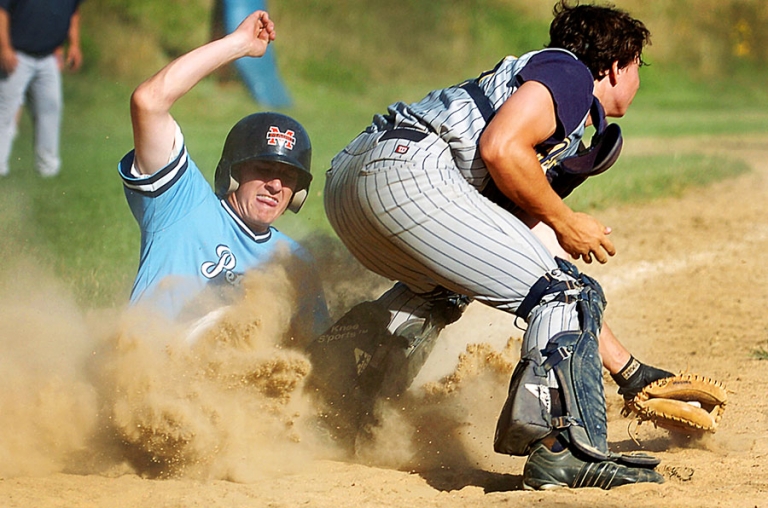 Sliding into home base during a baseball game in Salem, Massachusetts.