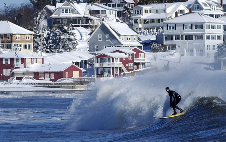 Winter surfer on a big swell at Good Harbor Beach in Gloucester, Massachusetts.
