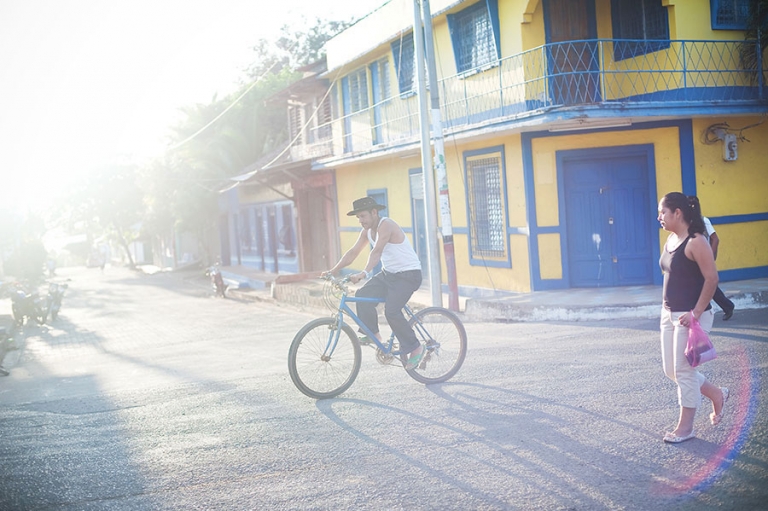 Cowboy hat man riding bike on the streets of Isla de Ometepe Nicaragua.