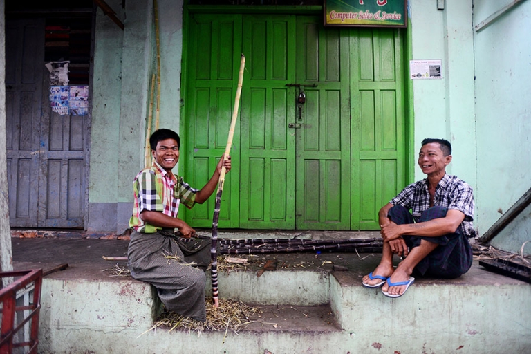Two man shave sugar cane before selling it's sweet juice on the streets of downtown Yangon, Myanmar. - Kira Horvath Photography