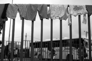 Clothes hang on a fence at the bus Belgrade bus station where the refugee crisis keeps flooding the station. - Kira Horvath Photography