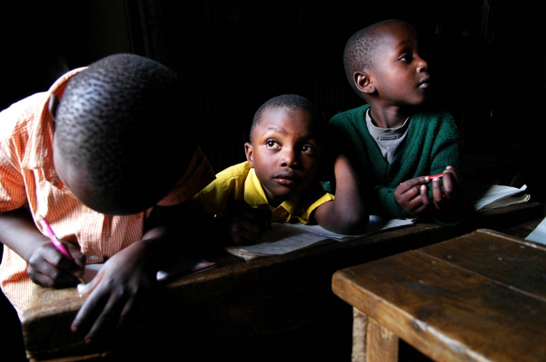 A boy stares out the window while taking a break from his English alphabet exercises at the Kitui Village Community Nursery School in the Majengo Slums of Nairobi, Kenya. Started by the Foundation for Orphaned Children, registered in 2005, the school acts as both daycare and school to the children who attend. The goal of this organization is to provide basic needs to the children such as food, clothing, education, shelter and health care. They are currently soliciting donations to provide these basic needs. Africa stock photography by Colorado photographer Kira Vos.