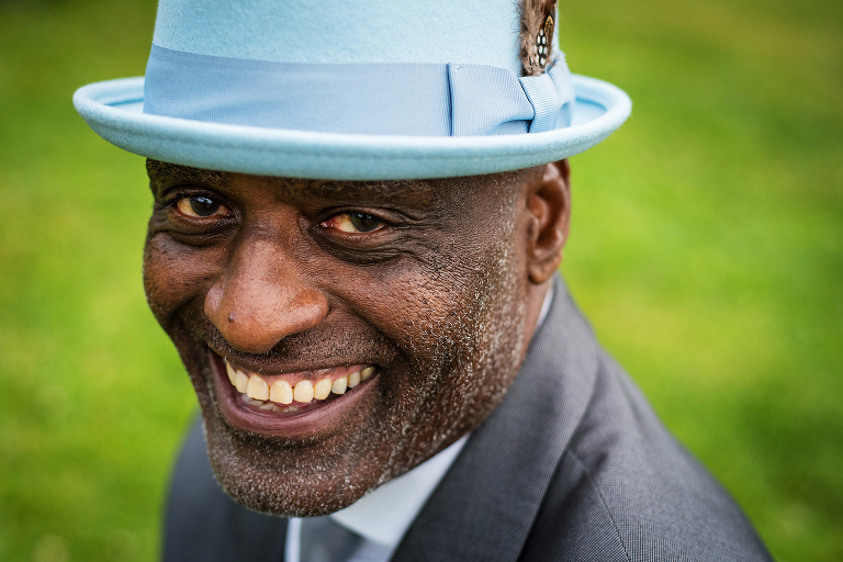 An African American man smiles while wearing a light blue fedora in Boulder, Colorado. Portrait and headshot photography from Boulder, Colorado.